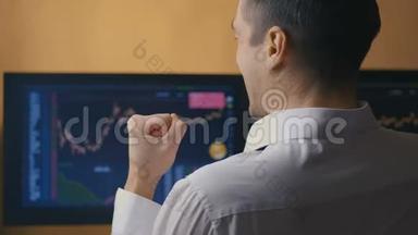 男商人正在电脑显示器上研究销售图表。 经纪人正在看股票销售统计